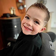 Malonn participe au concours pour gagner de l'argent avec cette photo : child, boy, smile, haircut, barber_chair, portrait, happy, short_hair, person, indoor, black_clothing, face, eyelashes, hairstyle, barbershop, cute, young, skin, head, expression