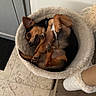 dog, small_dog, sleeping, curled_up, upside_down, relaxed, pet_bed, fluffy_bed, indoor, home, tile_floor, wooden_floor, cozy, brown_fur, black_fur, white_fur, paws, ears, animal_portrait, cute