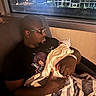 Noel joined the competition — help win amazing prizes! adult, baby, blanket, building, chair, city, glasses, indoor, man, newborn, night, person, portrait, window, wrapped, holding, tender, love, family, rest