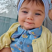 Siyanah participe au concours pour gagner de l'argent avec cette photo : baby, child, headband, bow, blue_clothing, yellow_cardigan, smile, face, tattoo, arm, holding, window, reflection, patterned_shirt, person, portrait, cute, indoor, knitted, casual_clothing