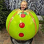 Kevin is registered to the contest to win money with this photo: child, toddler, smiling, christmas_ornament, holiday, festive, pine_tree, snow, winter, outdoor, green, red, decoration, happy, cute, playful, background, nature, fun, portrait