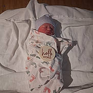 Christopher is registered to the contest to win money with this photo: newborn, baby, sleeping, swaddled, blanket, hat, portrait, face, indoors, bed, bedding, white, wooden_wall, infant, peaceful, cuddly, announcement_card, hello_world, nursery