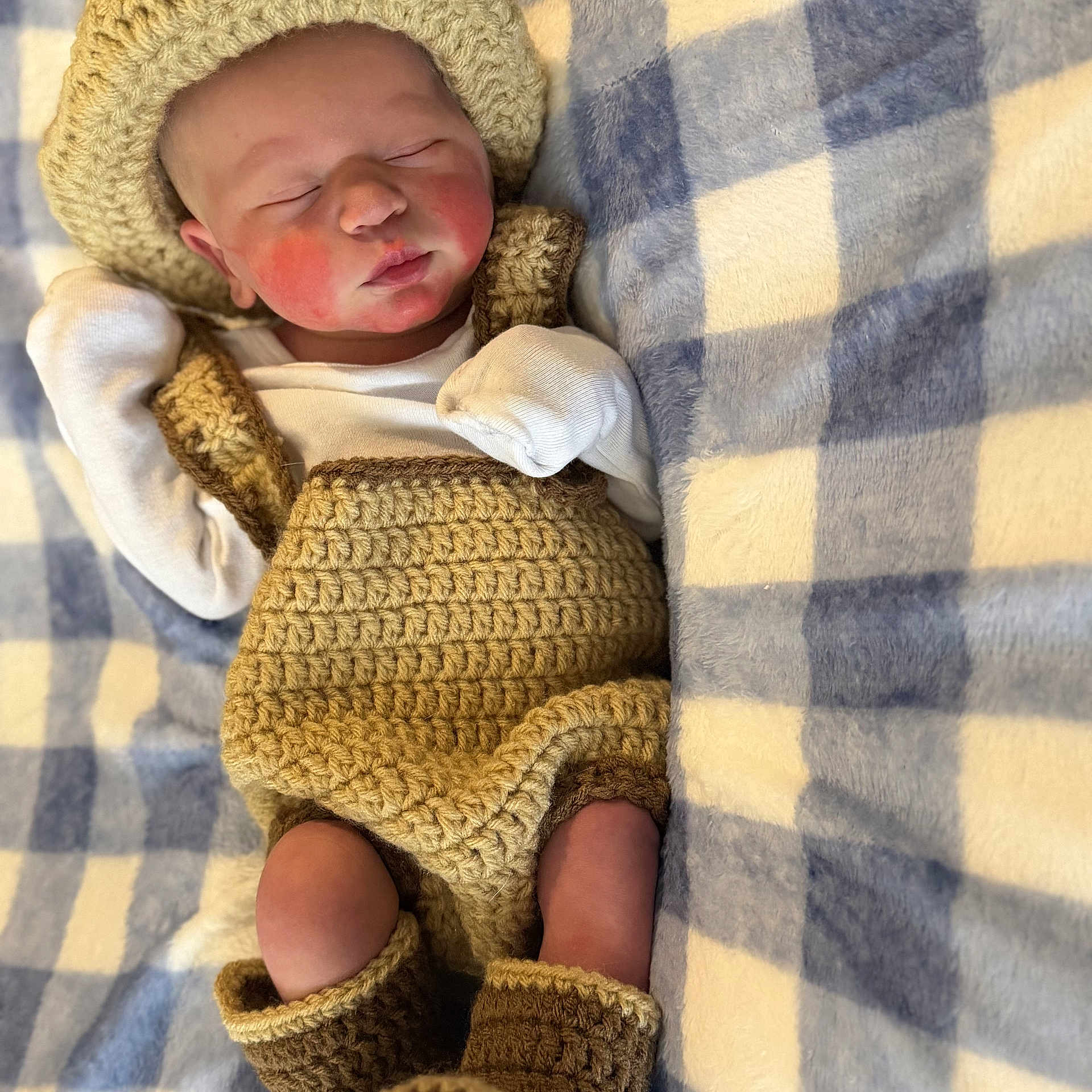 Christopher joined the competition — help win amazing prizes! newborn, baby, sleeping, portrait, crochet, knitted_clothing, hat, booties, blanket, checkered_pattern, cozy, peaceful, infant, indoors, close_up, lying_down, white_shirt, hand_mittens, textile, cute