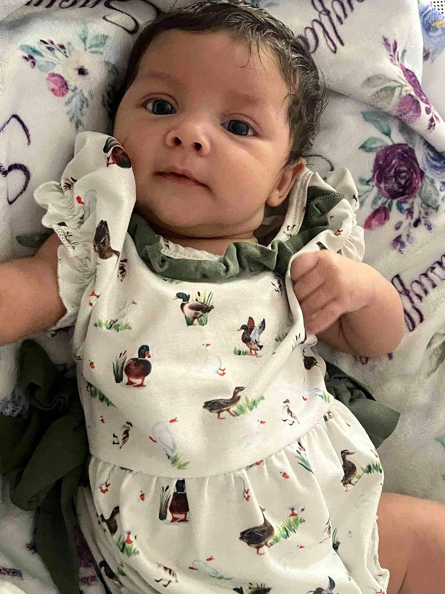 Berkleigh is registered to the contest to win money with this photo: baby, birds, blanket, child, closeup, clothing, cute, dress, ducks, eyes, face, floral, hand, indoors, infant, laying, pattern, portrait, skin, young