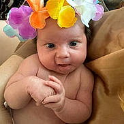 Sophie-Louise is registered to the contest to win money with this photo: baby, infant, flower_crown, hands, skin, face, blue_eyes, cheeks, couch, blanket, comfort, cute, indoors, portrait, toddler, expression, soft_lighting, child, clothing, closeup
