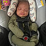 Hezakiah is registered to the contest to win money with this photo: baby, car_seat, sleeping, infant, seat_belt, green_clothing, cushion, patterned, toy, child, peaceful, indoor, closeup, cute, comfort, safety, head_support, resting, infant_clothing, strap