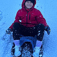 Caden joined the competition — help win amazing prizes! child, sled, snow, winter, red_jacket, gloves, white_shoes, purple_socks, smiling, outdoor, cold_weather, snowy_ground, play, fun, frozen, recreation, happy, person, clothing, footwear