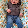 baby, child, smile, hoodie, jeans, sneakers, blanket, animal_print, giraffe, lion, tiger, cute, happy, infant, sitting, indoors, portrait, clothing, footwear, casual