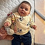 baby, infant, clothing, sweater, denim, toy, pacifier, crib, mattress, quilted, face, person, cute, child, indoor, soft_toy, baby_toys, blue, cream, denim_pants