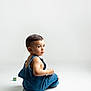 baby, casual_clothing, child, childhood, curious, cute, denim_overalls, floor, indoor, innocence, looking_back, minimalist, playtime, portrait, sitting, studio, toddler, toy_block, white_background, young_child
