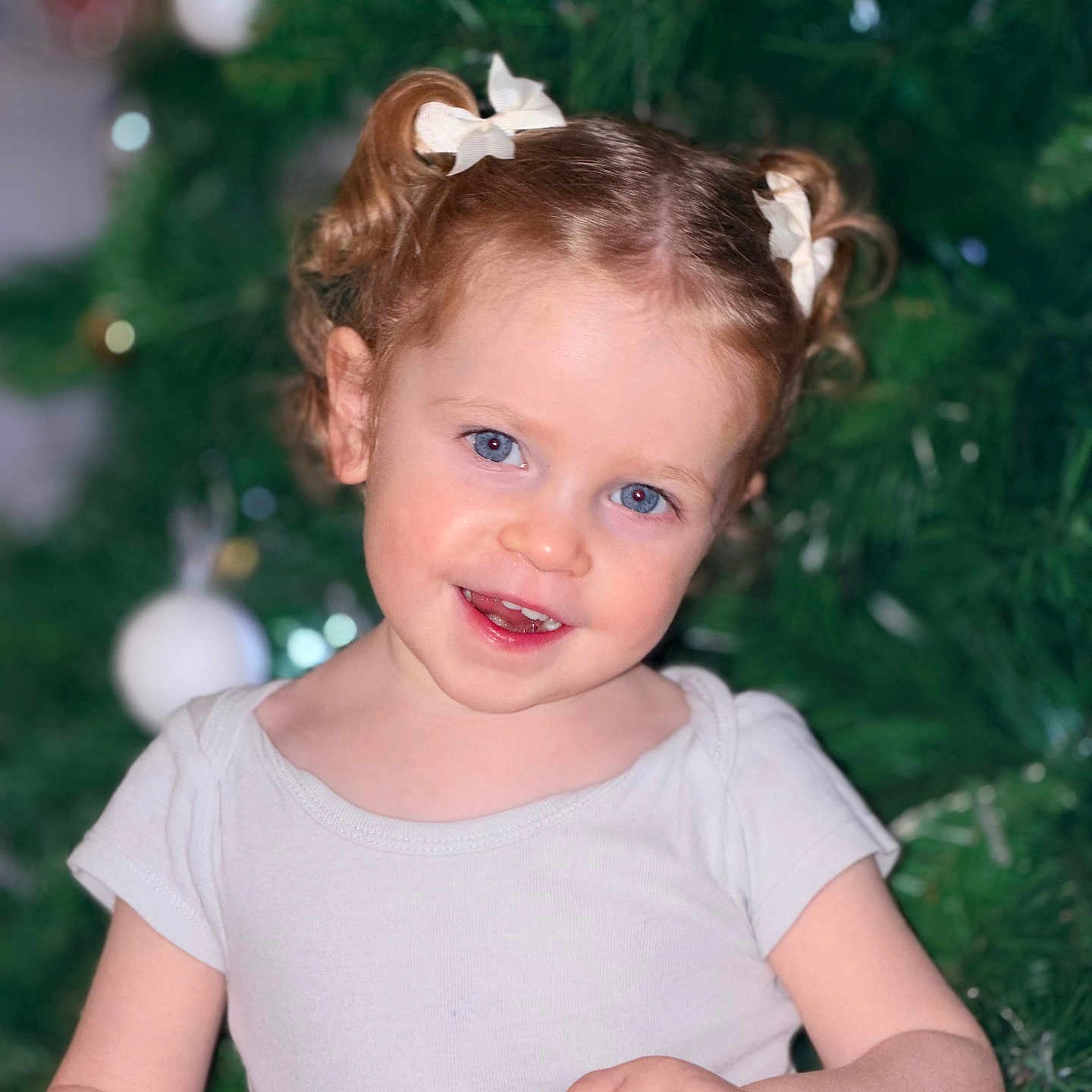Rosalia participe au concours pour gagner de l'argent avec cette photo : blue_eyes, celebration, child, christmas_tree, curly_hair, cute, decoration, festive, hair_bows, happy, holding_paper, holiday, indoors, ornaments, person, portrait, seasonal, smile, toddler, white_shirt