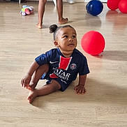Kyan a rejoint le concours — aidez-le/la à gagner de superbes lots ! toddler, child, indoor, floor, balloons, toy, sports_jersey, paris_saint_germain, curious, sitting, barefoot, person, wooden_floor, red_balloon, blue_balloon, white_shorts, legs, home, playful, casual_clothing