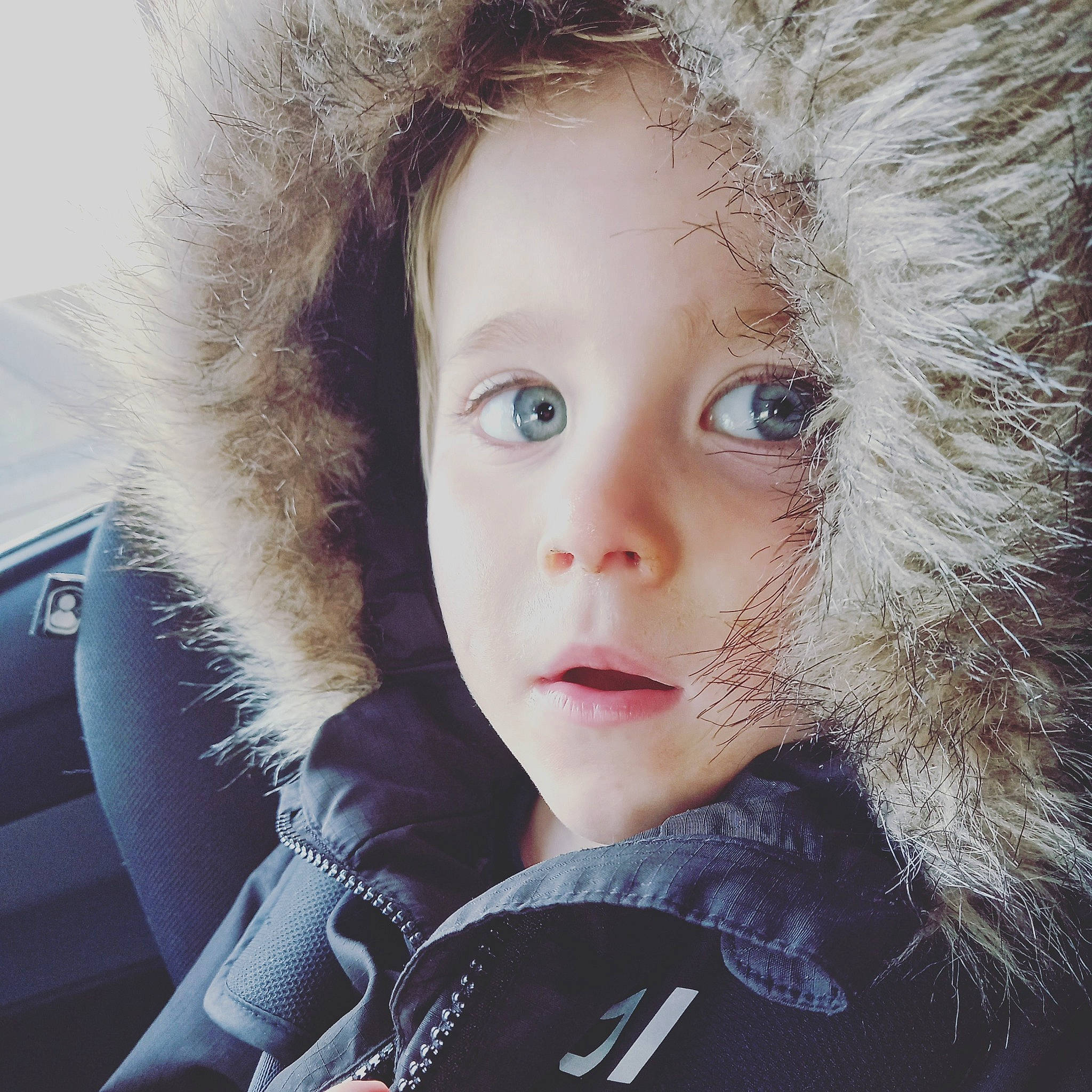 Luke is registered to the contest to win money with this photo: animal_product, cap, cool, eye, eyebrow, eyelash, flash_photography, fur_clothing, happy, headgear, human, iris, jacket, lip, nose, outerwear, parka, person, skin, toy