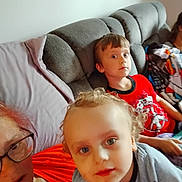Bellamy is registered to the contest to win money with this photo: child, toddler, adult, couch, indoor, casual, family, portrait, curly_hair, red_shirt, glasses, relaxed, living_room, blanket, seated, curious, young_child, home, people, cozy