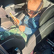 Bellamy joined the competition — help win amazing prizes! toddler, child, car_seat, sunglasses, curly_hair, chopsticks, blue_shirt, camouflage_pants, smile, sunlight, shadow, vehicle_interior, seatbelt, playful, casual_clothing, young_child, car, seat, portrait, happy