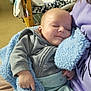 Kato is registered to the contest to win money with this photo: baby, infant, sleeping_baby, blanket, blue_blanket, hoodie, onesie, caregiver_partial, closeup, nursery, play_gym, toy, crib, plush_toy, hand, lap, indoor, cozy, portrait, smile