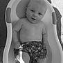 Leo is registered to the contest to win money with this photo: baby, child, tub, water, swim_shorts, bare_chest, concrete_floor, shadow, sunlight, sitting, infant, cute, outdoor, relaxing, skin, person, summer, bath, playful, expression