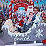 child, baby, santa_claus, christmas, holiday_backdrop, sled, teddy_bear, candy_cane, winter, snow, glasses, smile, family, portrait, festive, decoration, bell, red_costume, greeting_sign, seated