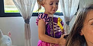 Hélya participe au concours pour gagner de l'argent avec cette photo : child, girl, princess_dress, hair_brushing, woman, indoor, curtains, window, stuffed_unicorn, toy, playful, blonde_hair, purple, pink, yellow, fabric, person, home, interaction, casual