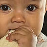 Skylah is registered to the contest to win money with this photo: baby, bread, child, close_up, cute, eating, expression, eyes, face, fingers, food, hand, infant, innocence, mouth, natural_light, portrait, skin, soft_light, young