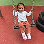 Hilona a rejoint le concours — aidez-le/la à gagner de superbes lots ! casual_clothing, chains, child, cute, daylight, feet, fun, happy, outdoor, pants, person, play, playground, seat, shoes, smiling, sweater, swing, tires, young
