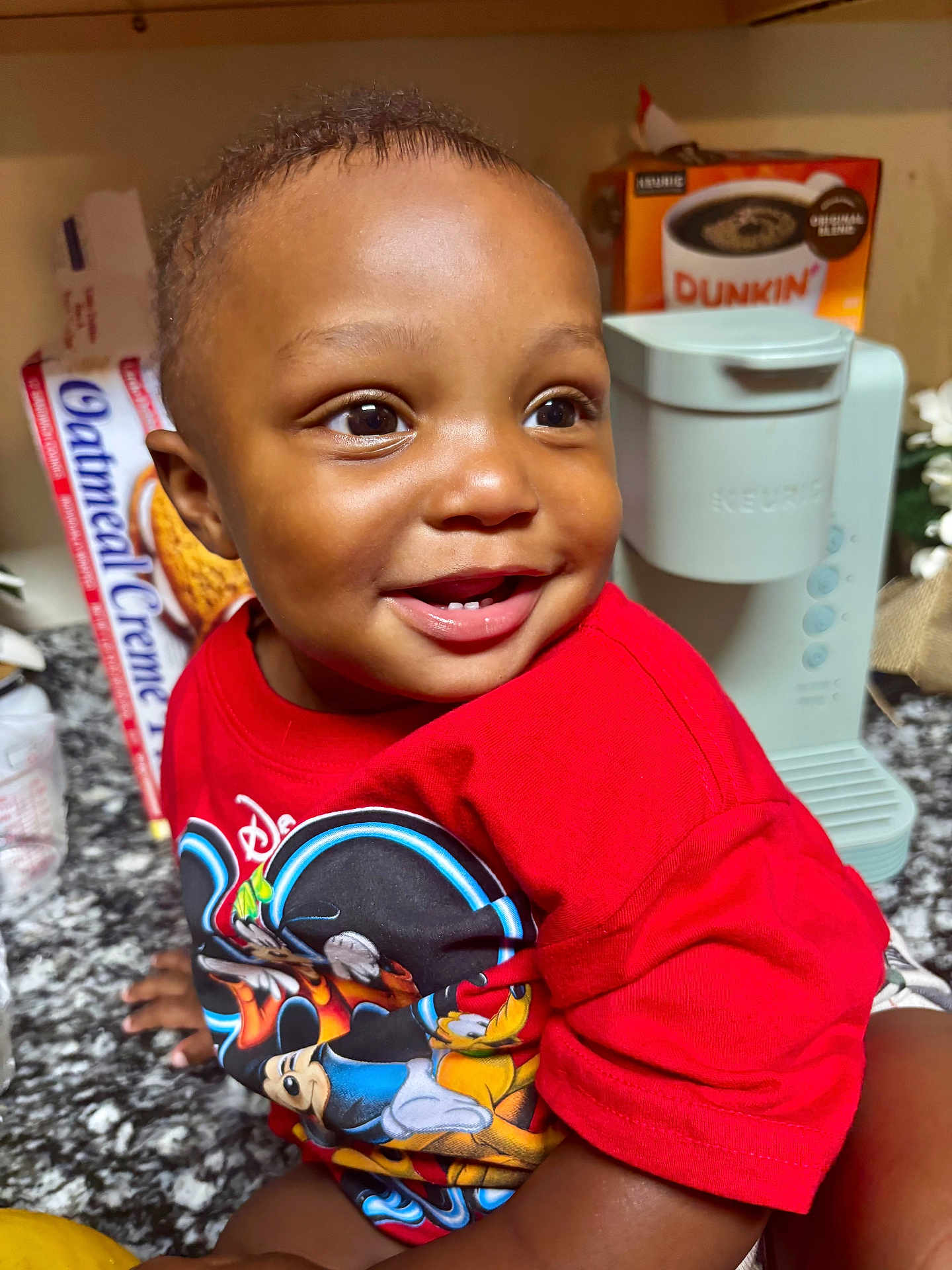 Tierre Aka Fatman is registered to the contest to win money with this photo: toddler, child, smiling, red_shirt, mickey_mouse, kitchen, countertop, keurig, coffee_box, happy, portrait, indoor, face, person, cute, baby, short_hair, bright_eyes, expression, clothing