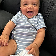 Brayden is registered to the contest to win money with this photo: baby, babylaughing, clothing, couch, diaper, face, furniture, happy, head, laughing, pants, person, photography, portrait, shorts, sitting, smile, t_shirt