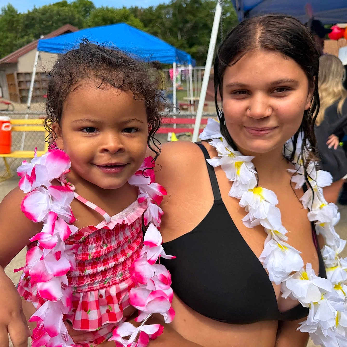 Journey joined the competition — help win amazing prizes! child, young_woman, outdoor, summer, lei, flower_garland, bikini_top, pink_clothing, smiling, happy, people, park, tent, bench, casual, daylight, curly_hair, skin, portrait, festive
