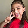 casual, child, cute, face, friendly, gesture, girl, hair_tie, hand, happy, indoor, long_hair, missing_teeth, peace_sign, person, portrait, red_shirt, skin, smile, young
