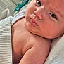 George is registered to the contest to win money with this photo: arm, baby, child, close_up, cute, expression, face, human, indoors, infant, newborn, person, portrait, resting, skin, sleepwear, soft_light, towel, wrapping, young
