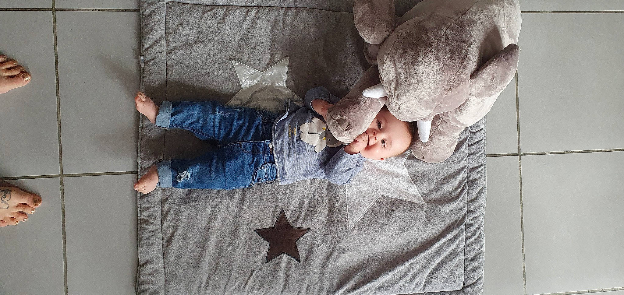 Nohé participe au concours pour gagner de l'argent avec cette photo : baby, baby_products, baby_toddler_clothing, bedding, bedtime, child, comfort, flooring, gesture, grey, hand, leg, linens, pattern, person, product, room, sitting, textile, toddler