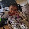 Mariana is registered to the contest to win money with this photo: child, girl, pajamas, hello_kitty, smiling, pose, chair, indoors, kitchen, living_room, wood_floor, furniture, casual_clothing, cute, person, home, hair_braids, table, socks, relaxed