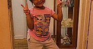 Mariana joined the competition — help win amazing prizes! cabinet, casual_clothing, child, cute, decor, flooring, girl, glass, happy, home, indoor, peace_sign, person, pink_shirt, posing, red_shoes, smile, toy, wooden_floor, young
