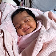 Drishti joined the competition — help win amazing prizes! baby, newborn, smile, sleeping, blanket, pink, soft, cute, infant, face, wrapped, child, cozy, indoors, portrait, happy, young, person, warm, resting