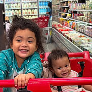 Alexia joined the competition — help win amazing prizes! child, baby, shopping_cart, grocery_store, smiling, happy, curly_hair, toddler, infant, person, retail, aisle, food_products, shelf, dairy, cart, clothing, indoor, family, cute