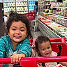 child, baby, shopping_cart, grocery_store, smiling, happy, curly_hair, toddler, infant, person, retail, aisle, food_products, shelf, dairy, cart, clothing, indoor, family, cute