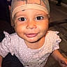 child, toddler, baby, portrait, face, close_up, wide_eyes, smiling, happy, hat, cap, polka_dot, dress, clothing, indoor, home, floor, person, photography, candid