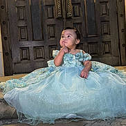 Arleth Lopez is registered to the contest to win money with this photo: toddler, child, dress, blue_dress, sparkle, princess, stairs, door, wooden_door, stone, outdoor, portrait, cute, thinking, person, baby, sitting, evening, fashion, formal_wear