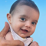 Elya a rejoint le concours — aidez-le/la à gagner de superbes lots ! baby, child, smile, hand, skin, face, eyes, clothing, outdoor, sky, blue_sky, cloud, infant, portrait, cute, happy, holding, person, closeup, young