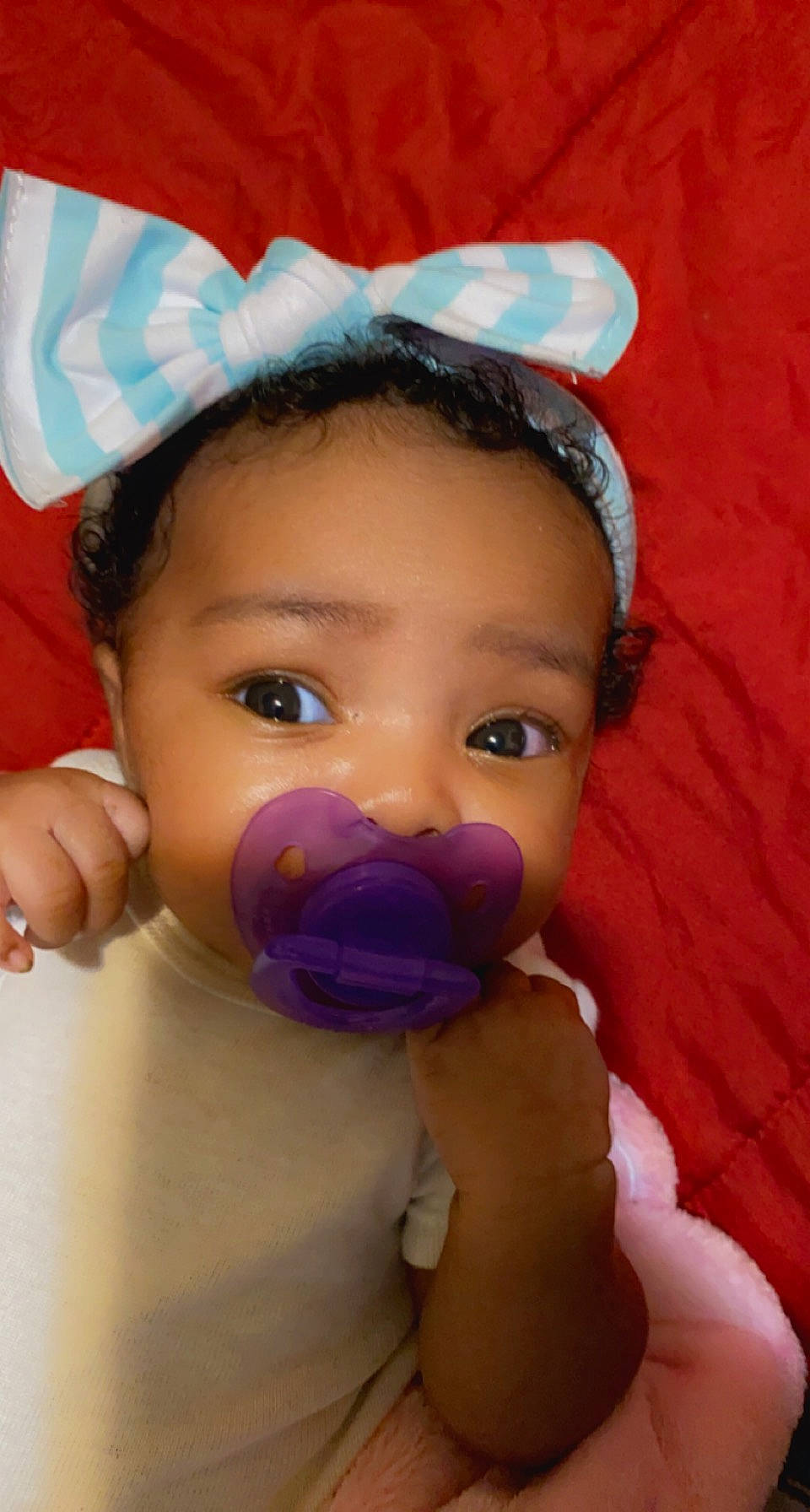 Alaska is registered to the contest to win money with this photo: baby, baby_toddler_clothing, cheek, child, comfort, ear, eye, eyebrow, eyelash, gesture, happy, iris, linens, lip, magenta, nose, person, pink, skin, thumb