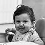 baby, bib, black_and_white, child, clothing, cute, expression, face, food, hair, high_chair, indoor, messy, person, playful, portrait, seat, smile, toddler, young