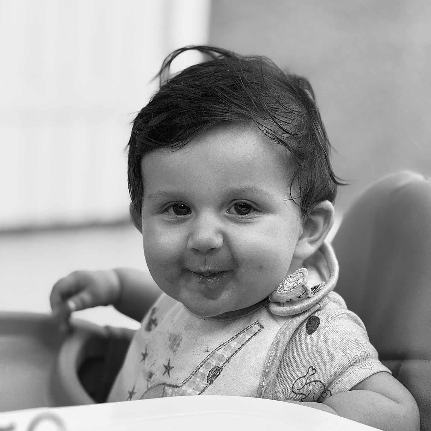 Soan participe au concours pour gagner de l'argent avec cette photo : baby, bib, black_and_white, child, clothing, cute, expression, face, food, hair, high_chair, indoor, messy, person, playful, portrait, seat, smile, toddler, young