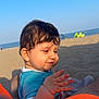 Soan participe au concours pour gagner de l'argent avec cette photo : baby, beach, blue_sky, casual, child, clothing, curly_hair, cute, daytime, hand, happy, outdoor, person, portrait, relaxing, sand, sea, summer, sunlight, vacation