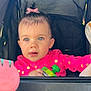 toddler, child, stroller, pink_jacket, bow, blue_eyes, snack_pouch, curious, baby, outdoor, playful, face, hands, clothing, seat, person, portrait, infant, cute, expression