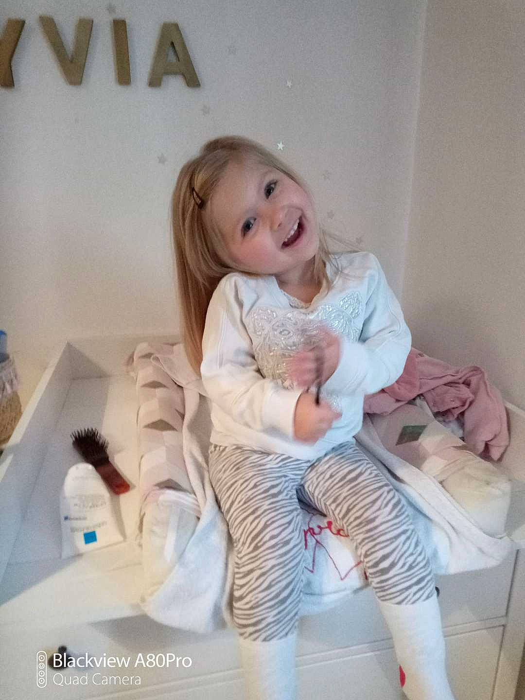 Lyvia participe au concours pour gagner de l'argent avec cette photo : blond, brown_hair, child, comfort, fashion_accessory, fashion_design, flash_photography, flooring, happy, human_body, human_leg, joy, knee, leg, long_hair, person, pink, sleeve, smile, sportswear