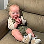 baby, child, clothing, couch, cute, face, footwear, furniture, happy, indoors, infant, overalls, person, shoes, sitting, skin, small, smiling, socks, young