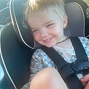 Canaan is registered to the contest to win money with this photo: baby, blonde_hair, car_interior, car_seat, casual_clothing, cheerful, child, child_seat, cute, happy, indoor, person, portrait, safety_harness, seat, seatbelt, smiling, sunlight, young_child, young_kid