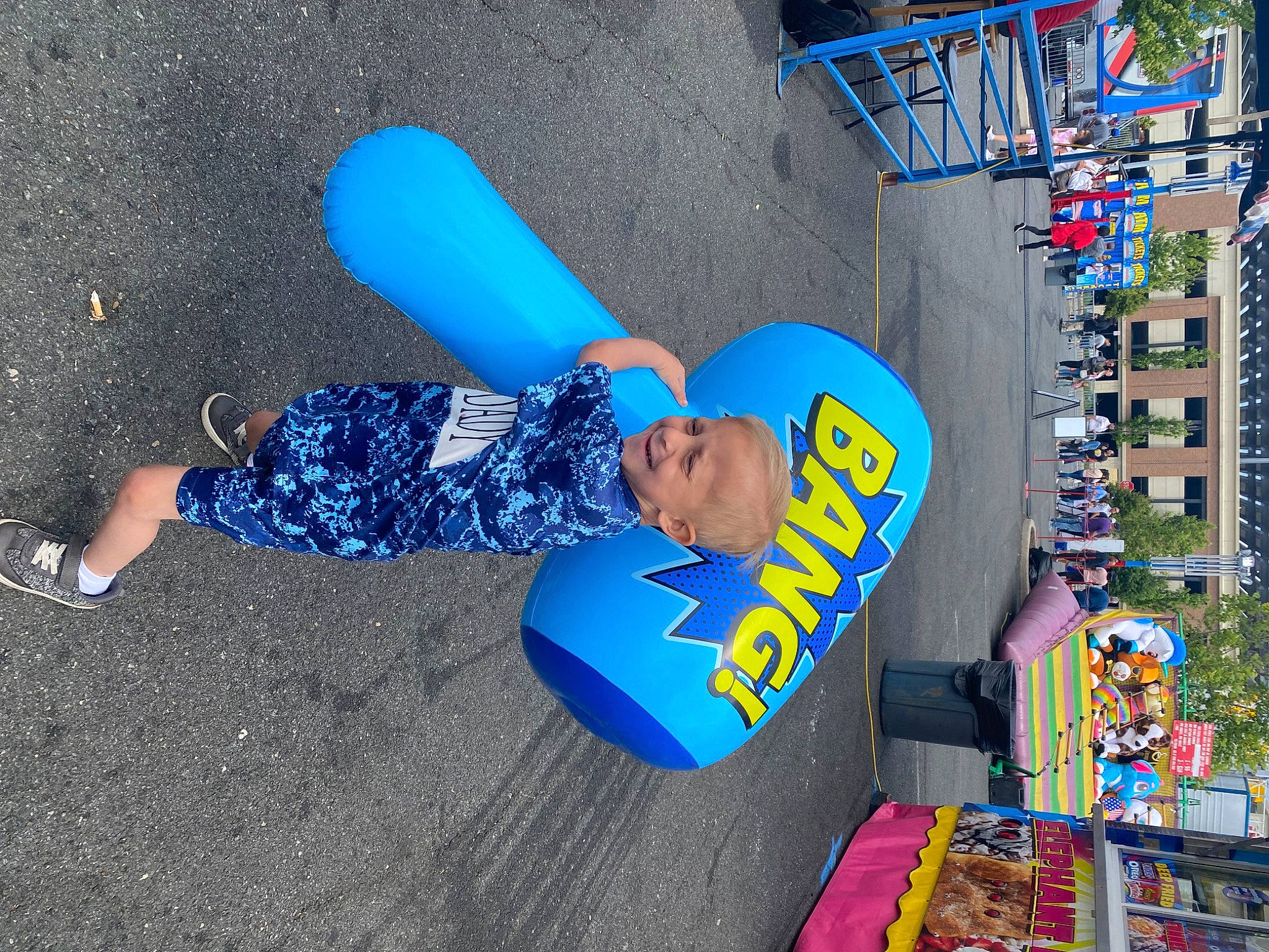 Rj Dawson is registered to the contest to win money with this photo: advertising, asphalt, city, concrete, electric_blue, fan, fun, hat, joy, leisure, logo, person, plastic, play, public_space, recreation, road_surface, sitting, t_shirt