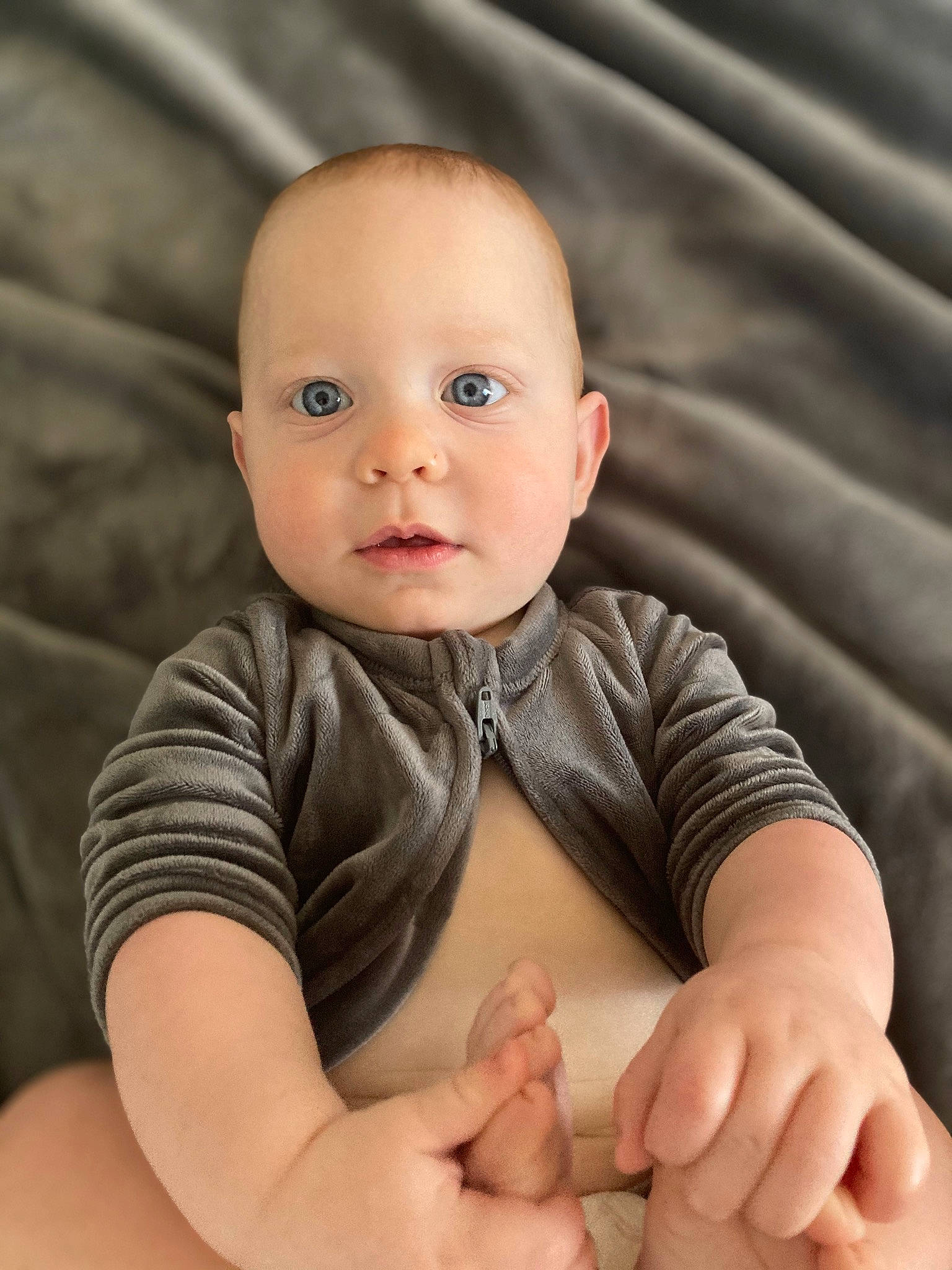 Jaxx is registered to the contest to win money with this photo: arm, baby, baby_toddler_clothing, cheek, chin, comfort, eye, eyebrow, flash_photography, gesture, hand, head, human_body, joint, nose, person, photograph, product, skin, sleeve