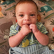 Spencer is registered to the contest to win money with this photo: animal_print, baby, blanket, cat_legs, child, closeup, clothing, cozy, cushion, cute, face, hands, home, indoor, infant, knit, pacifier, portrait, smiling, striped_shirt
